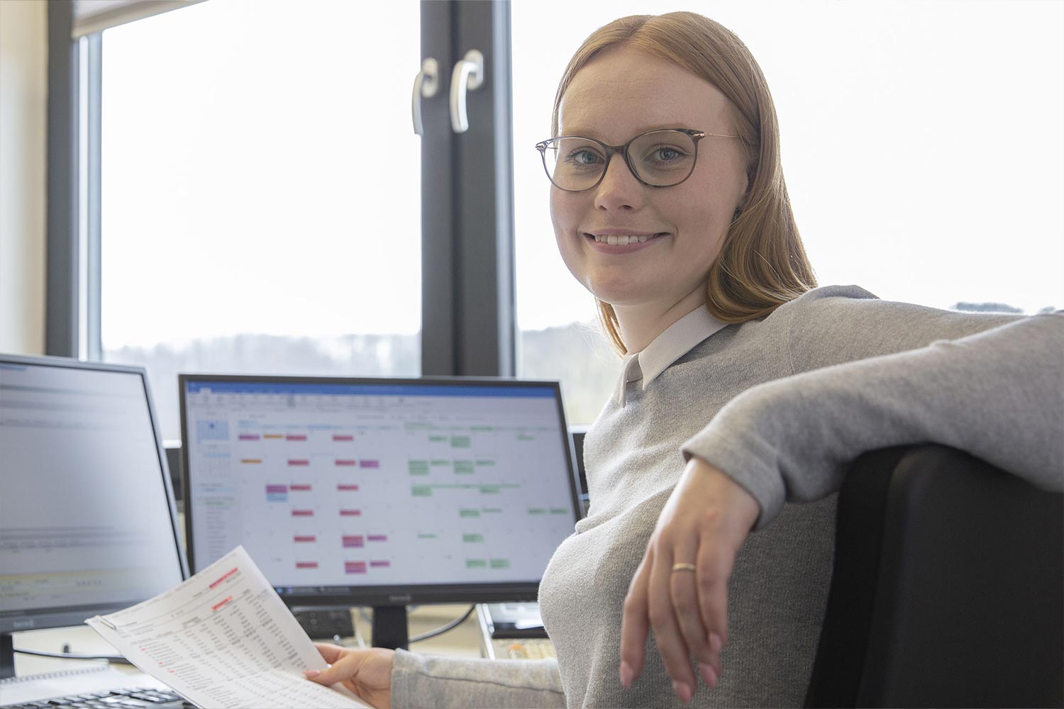 Blonde Frau am Computer lächelt in die Kamera